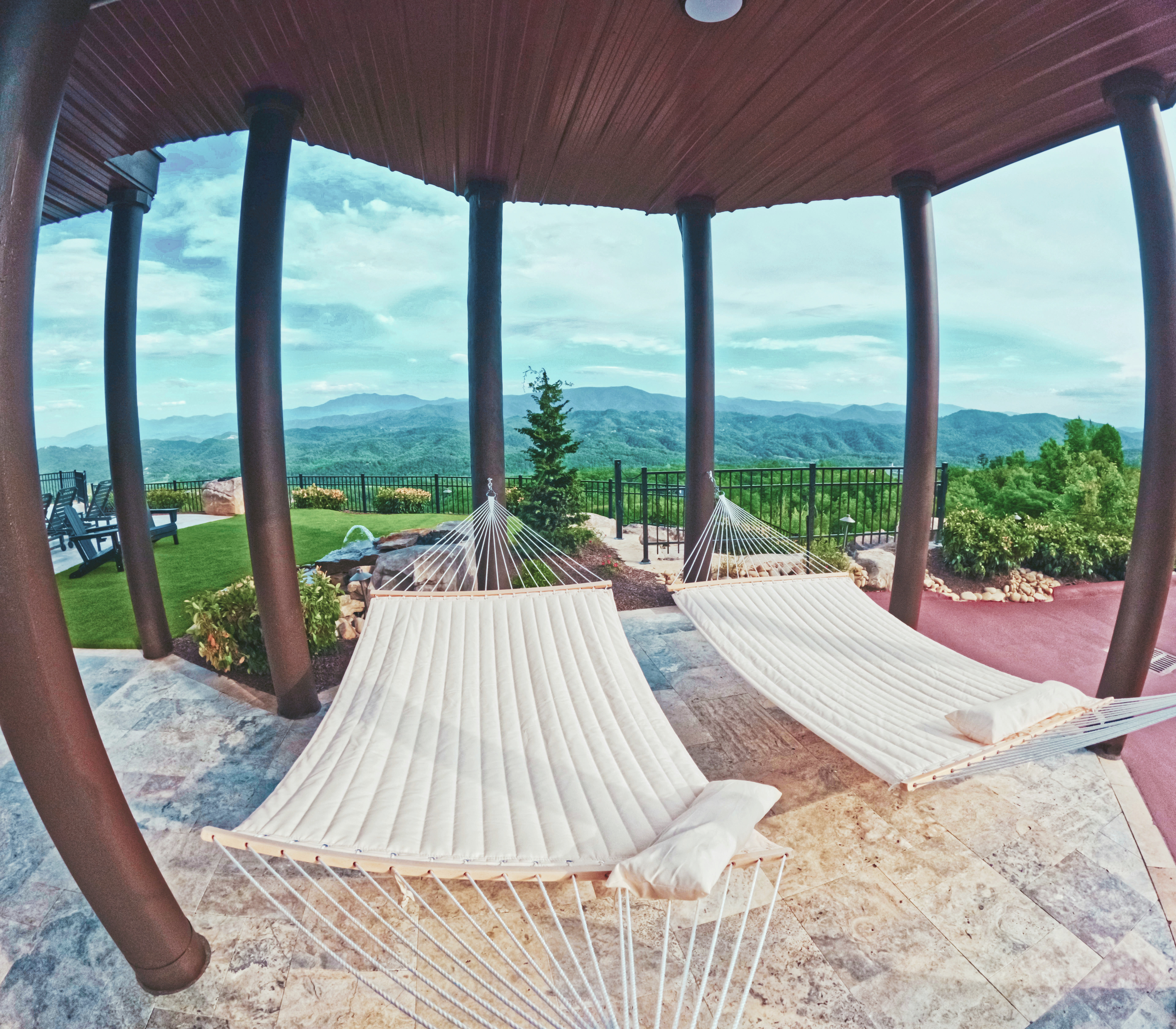 Covered outdoor living pavilion with hammocks and mountain views.