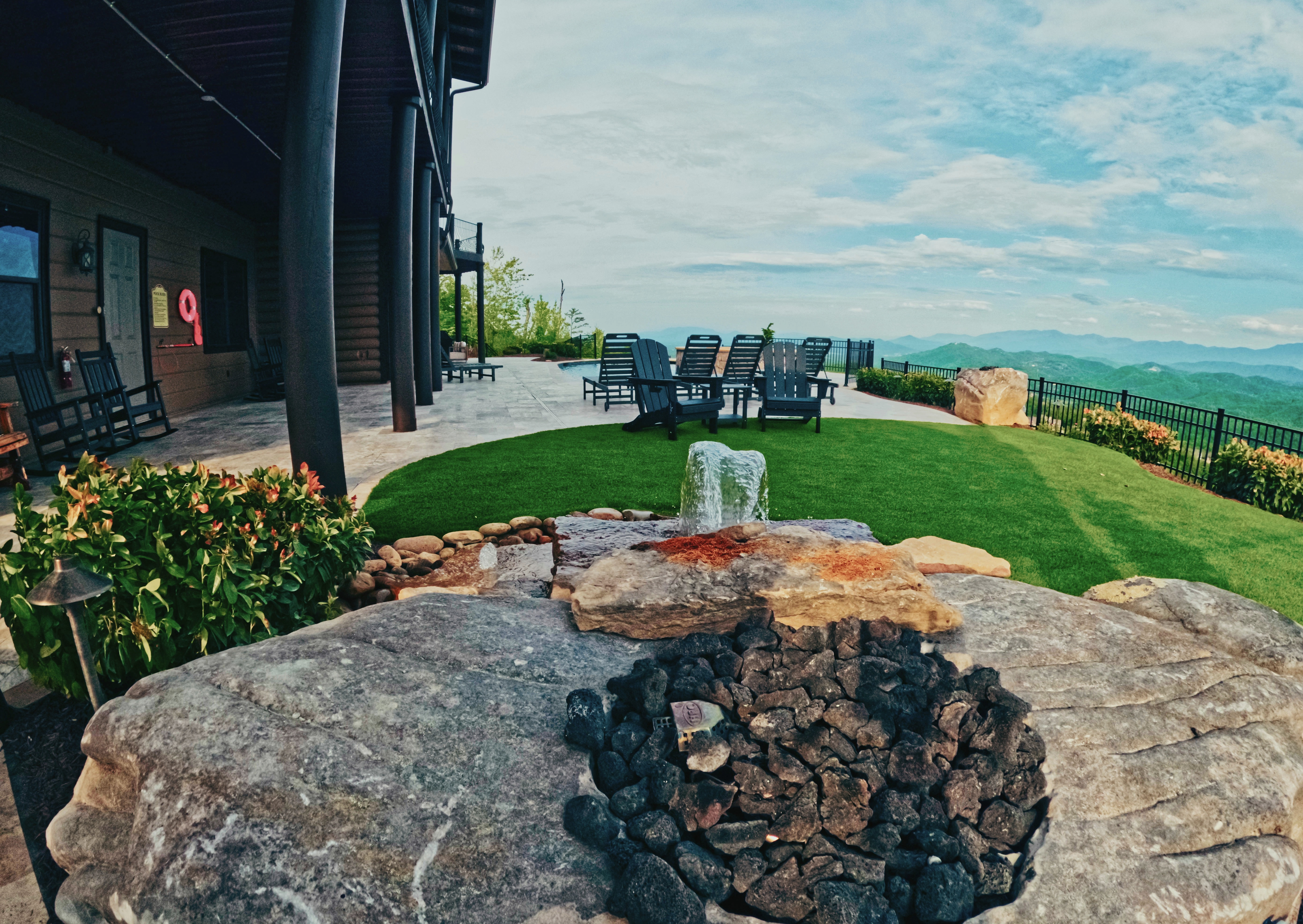 Custom water feature, lounge space, and mountain-view patio.