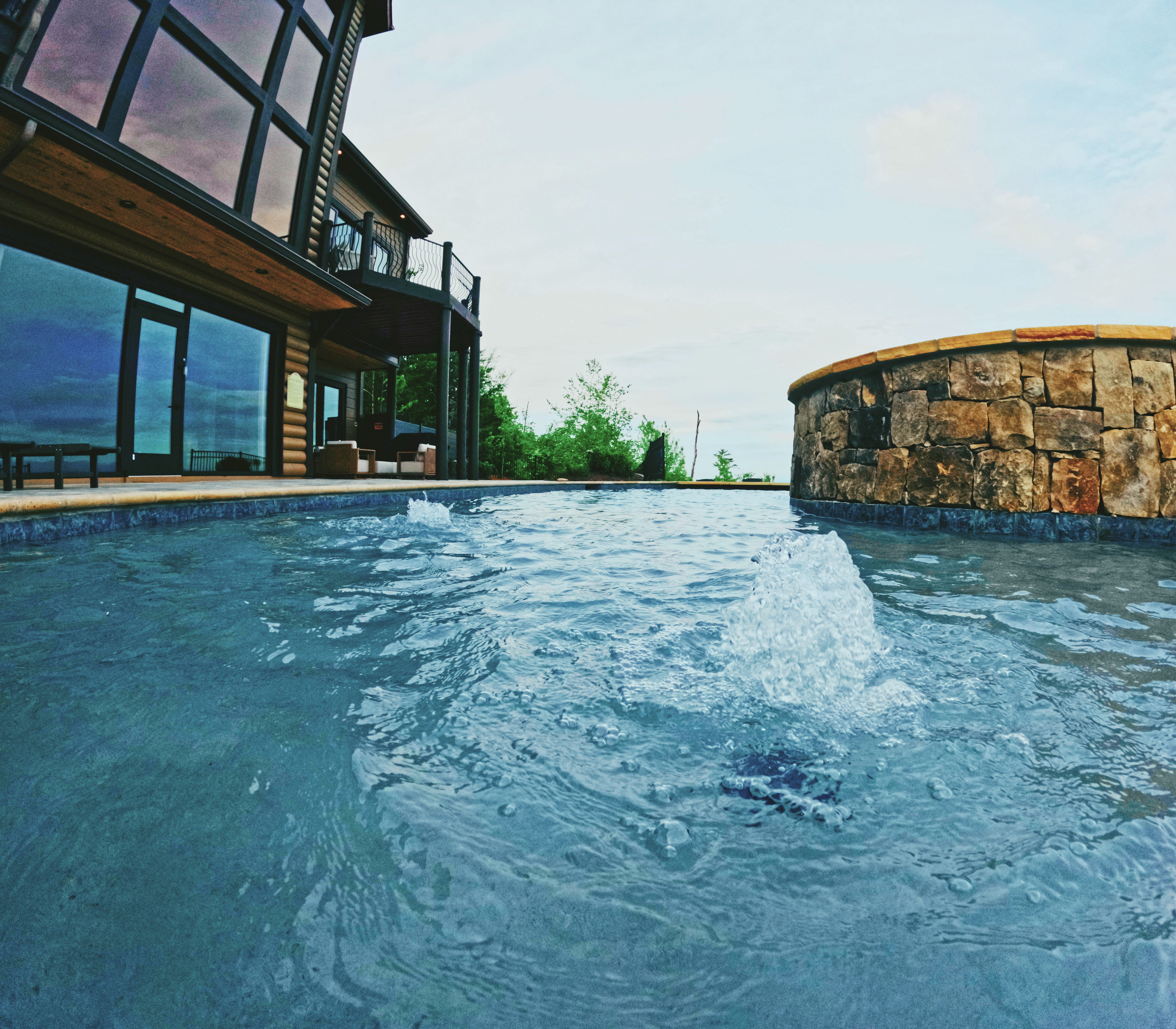 Custom pool with integrated stone spa and mountain-home setting.