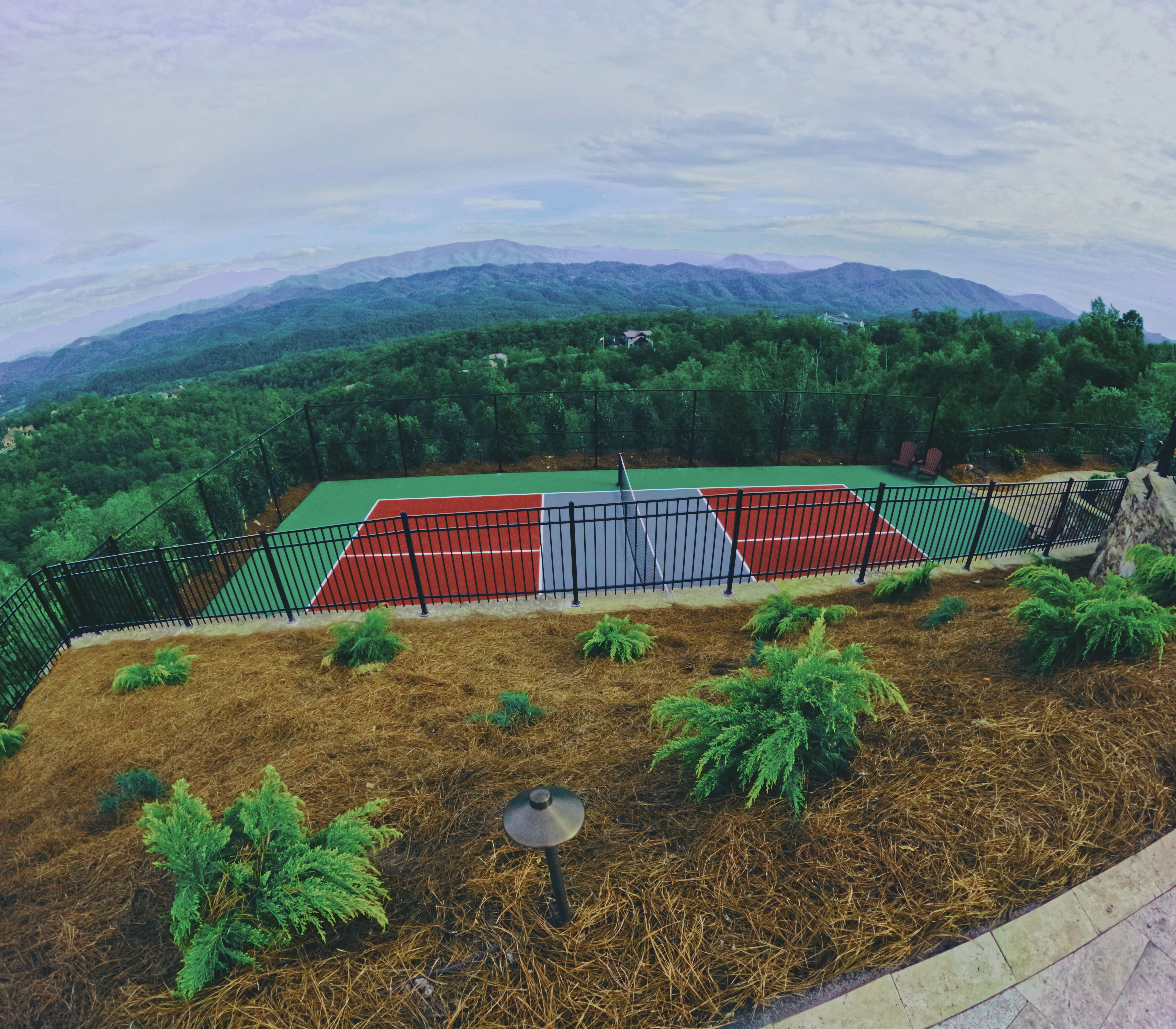 Elevated pickleball court set above a mountain landscape.