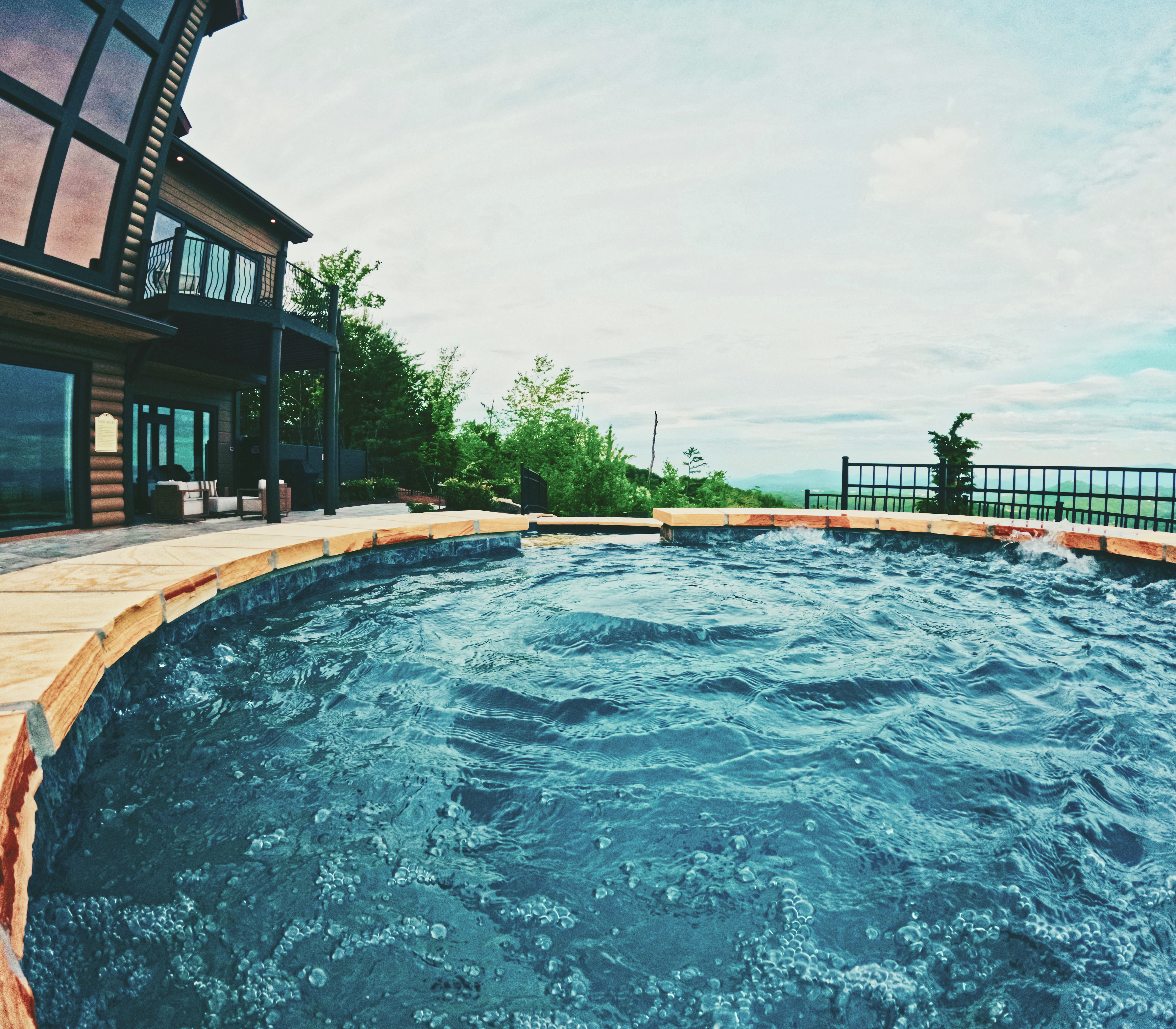 Custom pool with stone coping and a sweeping mountain outlook.