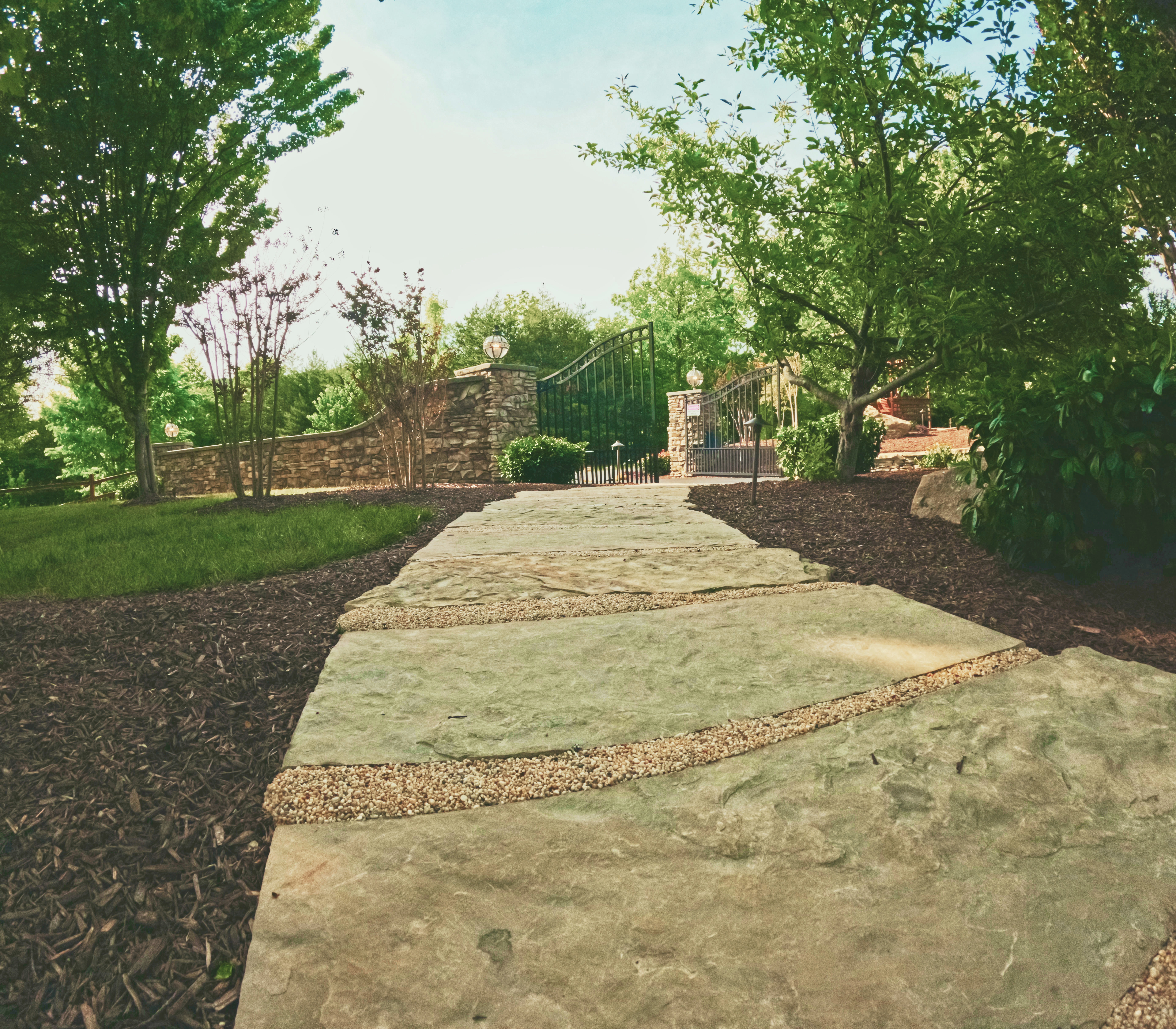 Natural stone garden pathway leading to a custom gated outdoor space.