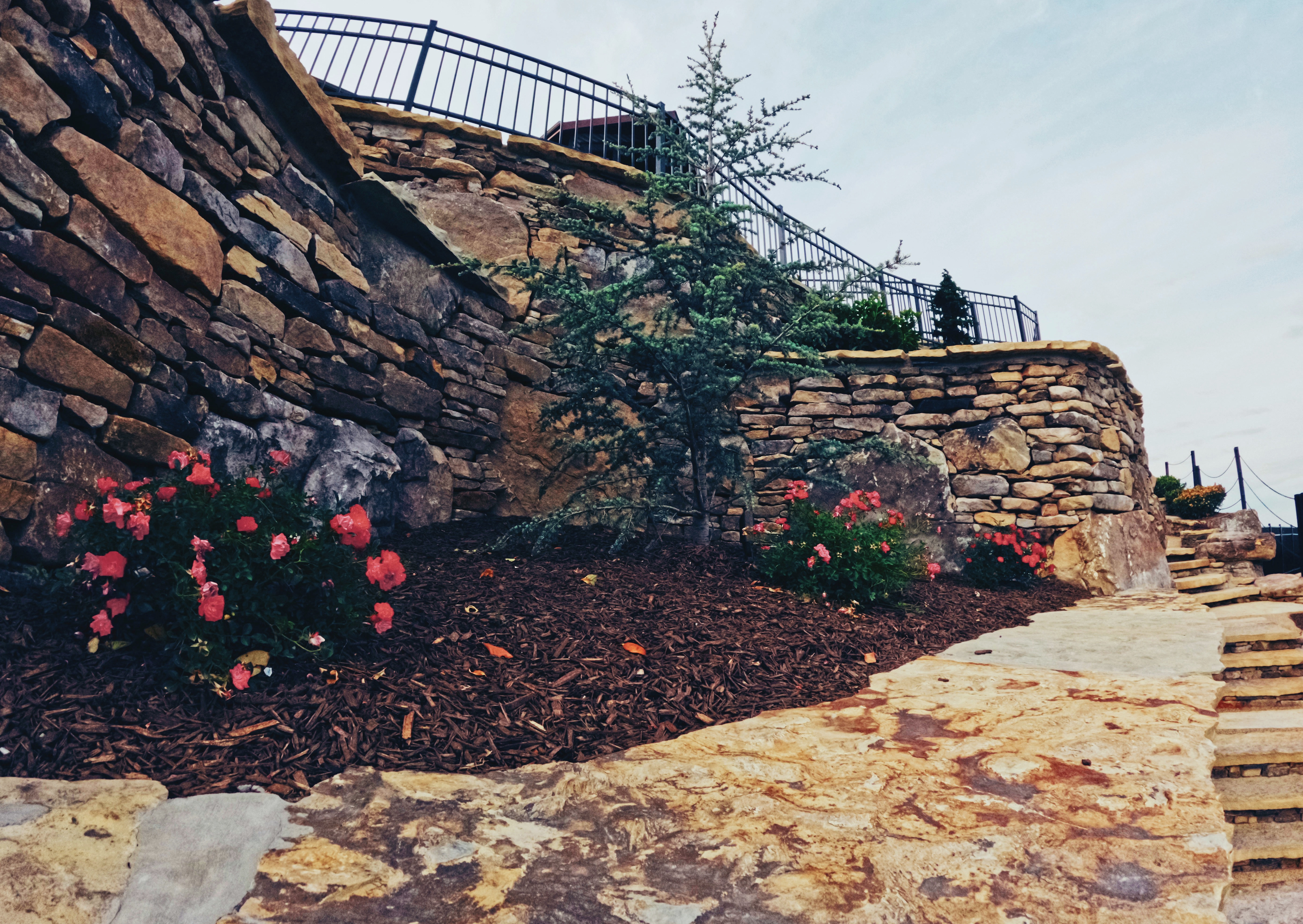Tiered natural stone retaining wall and stair system.