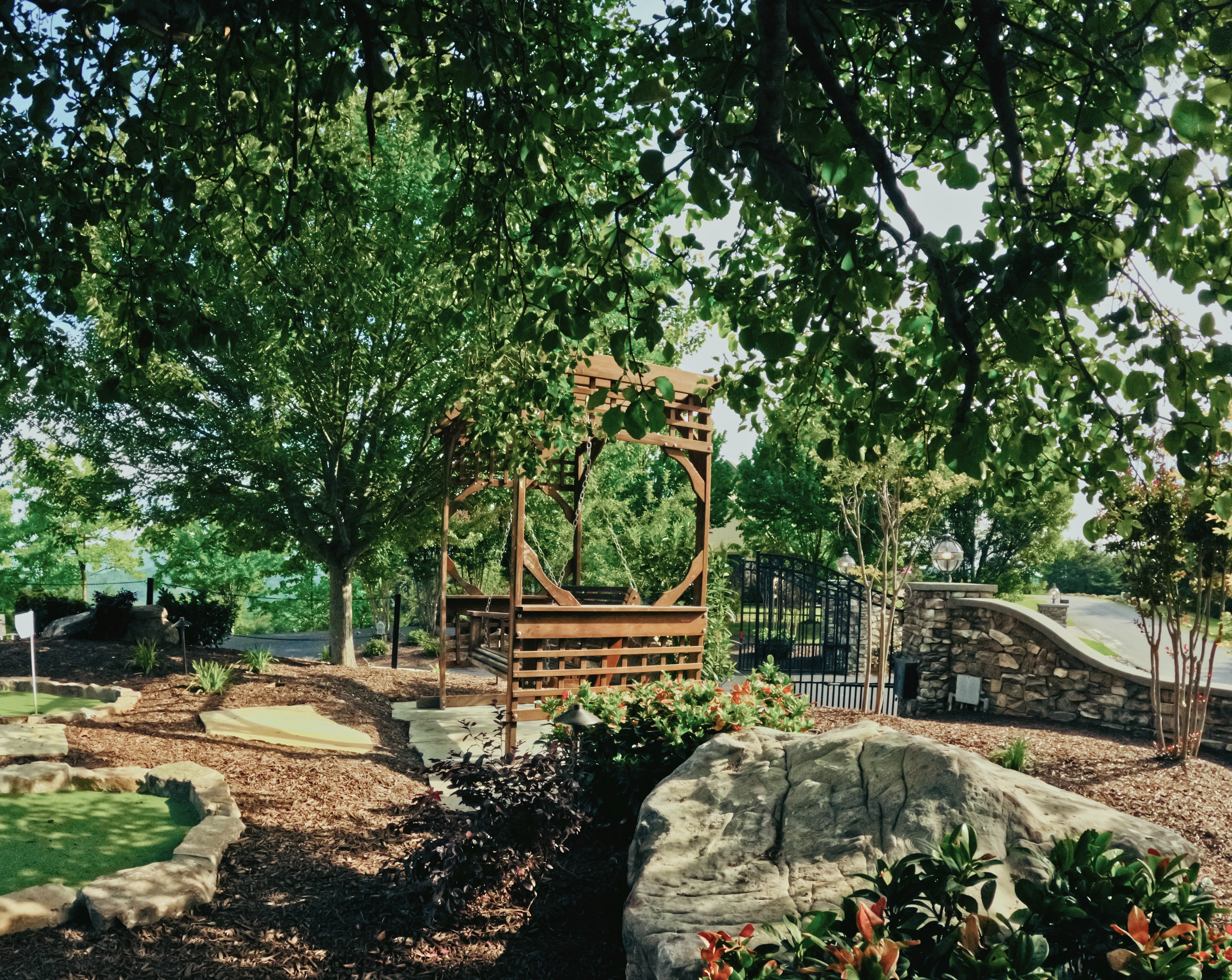 Garden pergola and outdoor recreation space framed by mature planting.